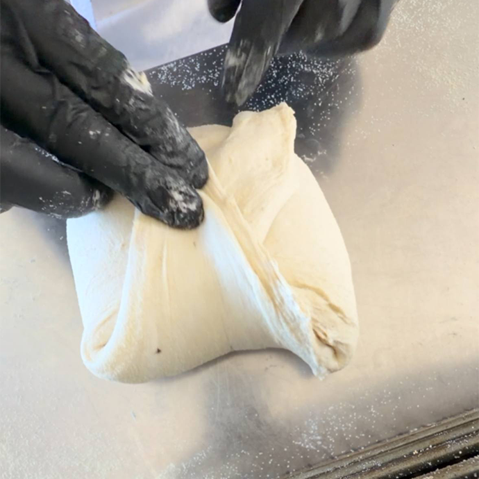 Lembo superiore dell'impasto portato verso il basso e premuto per chiudere