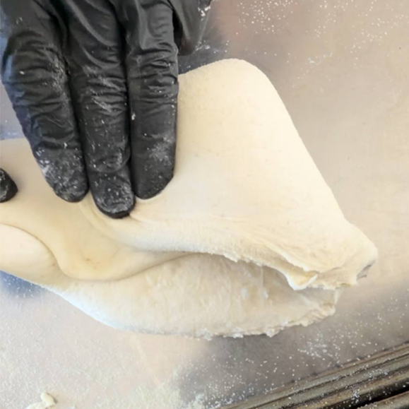 Lembo laterale dell'impasto stirato e portato al centro, per la chiusura a portafoglio