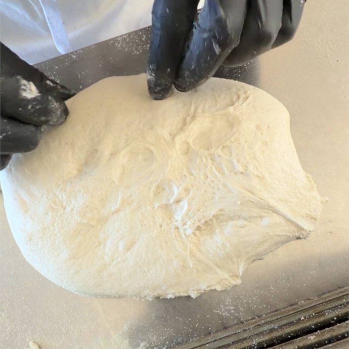 Impasto preformato capovolto sul banco infarinato, con la parte liscia sotto, pronto per la formatura